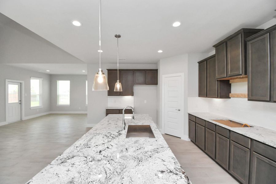With a massive granite island, high ceilings, soft close cabinets, granite countertops, stainless steel appliances (to be installed), a sleek tile backsplash, recessed lighting, and an extended counter area, it offers both style and practicality. All this opens up to the expansive family room, creating a perfect hub for gatherings. Sample photo of completed home with similar floor plan. Actual colors and selections may vary. With a massive granite island, high ceilings, soft close cabinets, granite countertops, stainless steel appliances (to be installed), a sleek tile backsplash, recessed lighting, and an extended counter area, it offers both style and practicality. All this opens up to the expansive family room, creating a perfect hub for gatherings. Sample photo of completed home with similar floor plan. Actual colors and selections may vary.