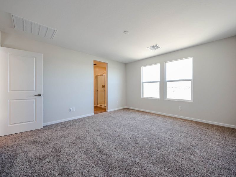 A room with a carpet and a door.