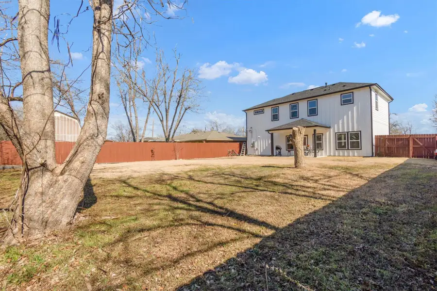 Rear view of house with a fenced backyard and a patio area