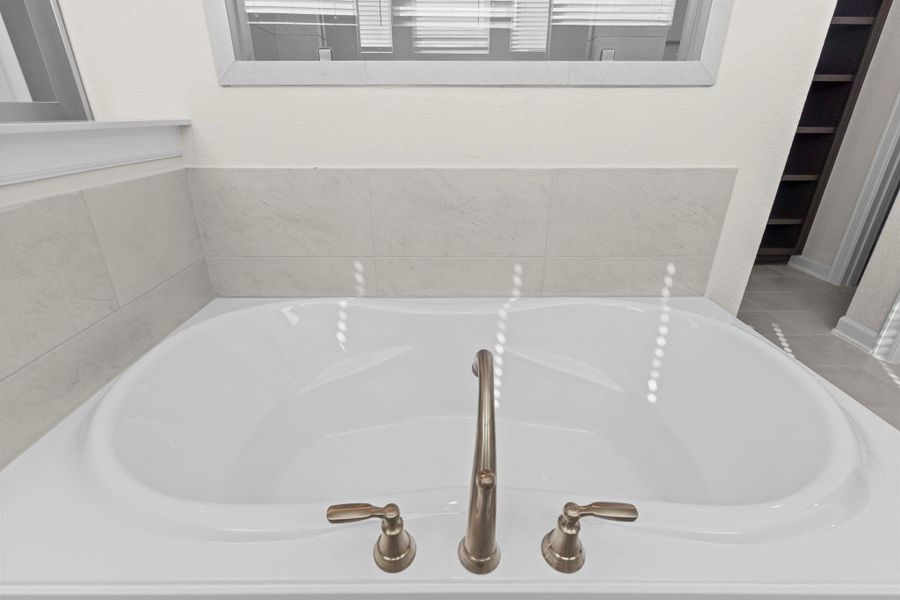 Relax and unwind in the luxurious soaking tub with tile surround, creating a private spa-like retreat within your own home.  Bubble me away and make that stress go away!  Sleek upgraded bathroom faucet.