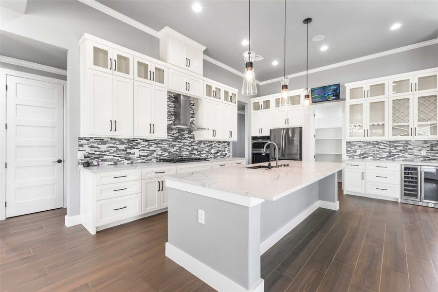 Kitchen featuring appliances with stainless steel finishes, beverage cooler, wall chimney range hood, crown molding, and backsplash Kitchen featuring appliances with stainless steel finishes, beverage cooler, wall chimney range hood, crown molding, and backsplash