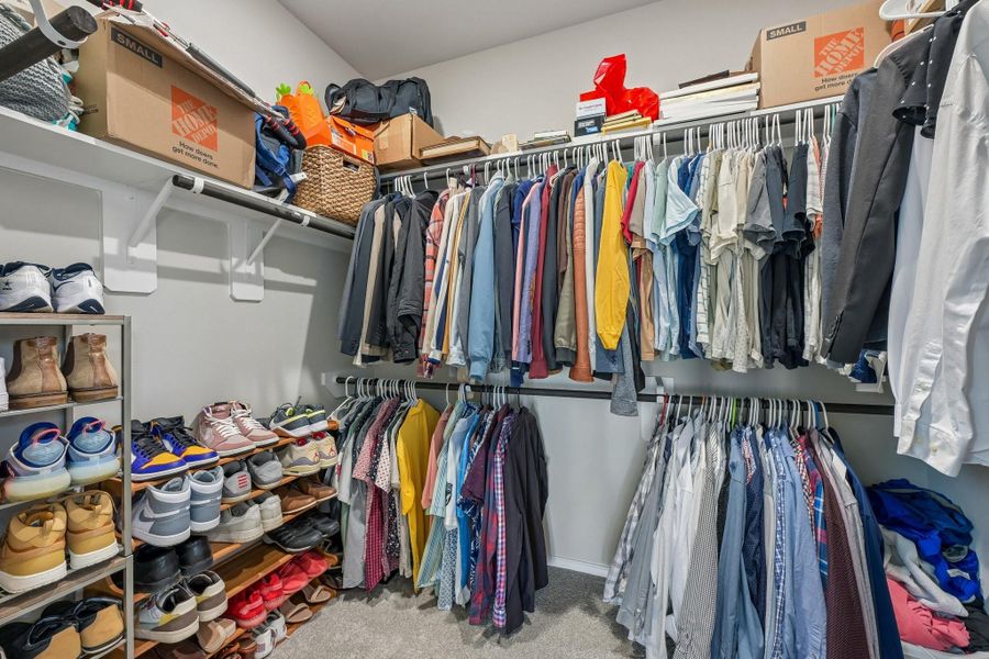 Spacious walk-in closet with ample shelving and hanging space, perfect for organizing your wardrobe and shoes.