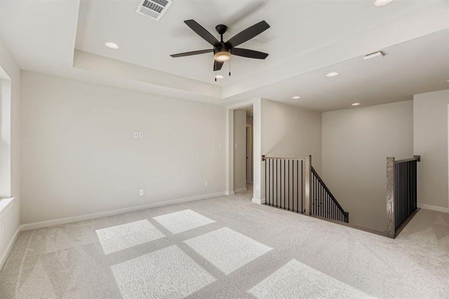 Carpeted spare room featuring recessed lighting, a tray ceiling, and ceiling fan