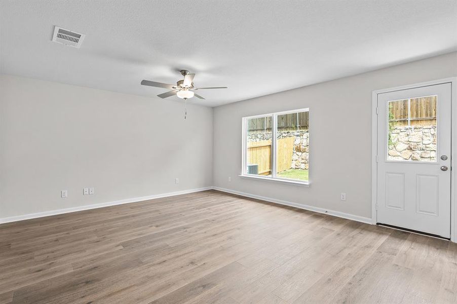 Entrance foyer featuring healthy amount of natural light, a ceiling fan, and wood finished floors