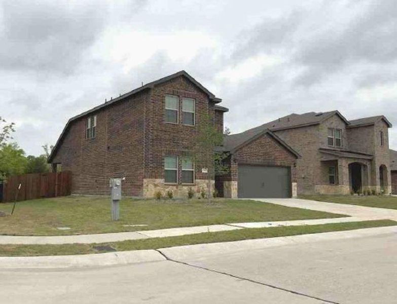 Front exterior of a new home in Woodcreek, Fate, TX, highlighting curb appeal (Image 2). Front exterior of a new home in Woodcreek, Fate, TX, highlighting curb appeal (Image 2).