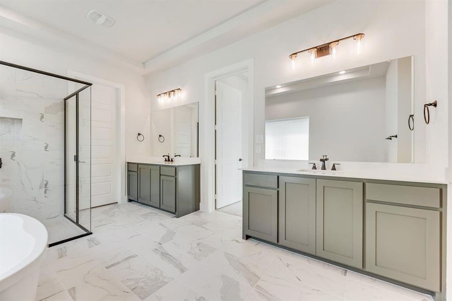 Bathroom with a marble finish shower, two vanities, light marble finish floors, and a soaking tub Bathroom with a marble finish shower, two vanities, light marble finish floors, and a soaking tub