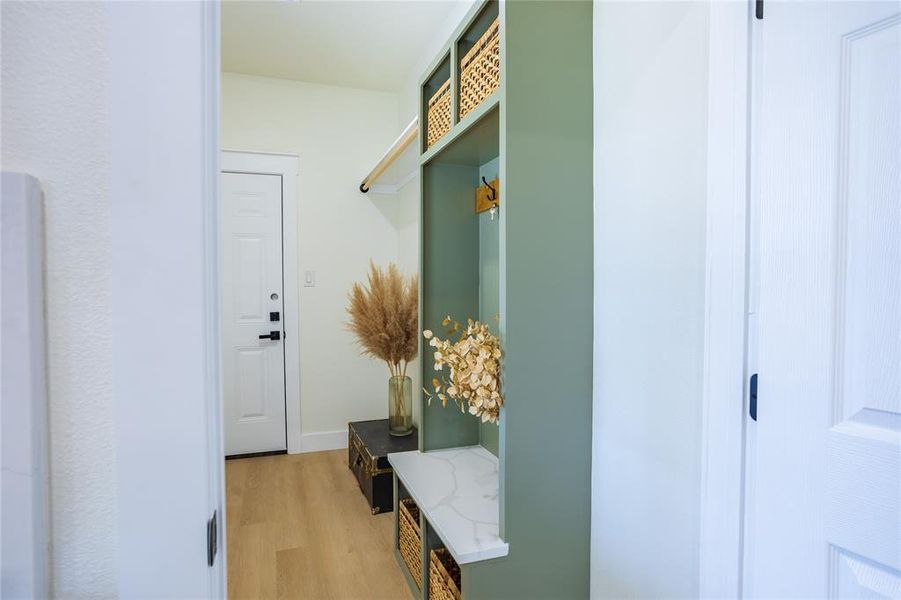 Mudroom with light wood-type flooring and baseboards