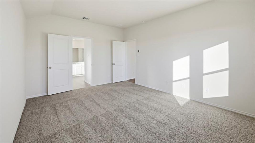 Unfurnished bedroom with carpet flooring and vaulted ceiling