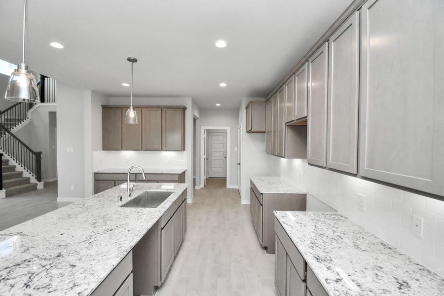 This kitchen is by far any chef’s dream! This spacious kitchen features high ceilings, stained wood cabinets, granite countertop, SS appliances, modern tile backsplash, recessed lighting, extended counter space, granite kitchen island with double sink, and space for breakfast bar, and a walk-in pantry all overlooking your huge family room. Sample photo of completed home with similar floor plan. Actual colors and selections may vary. This kitchen is by far any chef’s dream! This spacious kitchen features high ceilings, stained wood cabinets, granite countertop, SS appliances, modern tile backsplash, recessed lighting, extended counter space, granite kitchen island with double sink, and space for breakfast bar, and a walk-in pantry all overlooking your huge family room. Sample photo of completed home with similar floor plan. Actual colors and selections may vary.