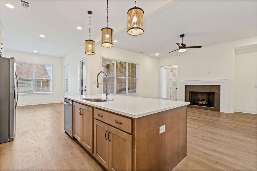 Open-concept living space with an expansive kitchen island featuring an undermount sink and a gooseneck faucet Open-concept living space with an expansive kitchen island featuring an undermount sink and a gooseneck faucet