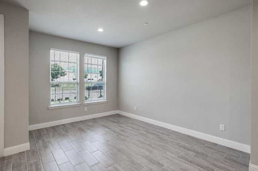 Spare room featuring light wood-style floors, baseboards, and recessed lighting