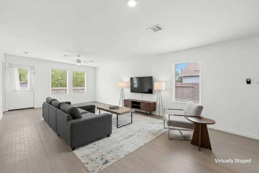 Virtually staged living area highlights the open layout, multiple windows, ceiling fan, and easy connection to the rear entrance. Virtually staged living area highlights the open layout, multiple windows, ceiling fan, and easy connection to the rear entrance.