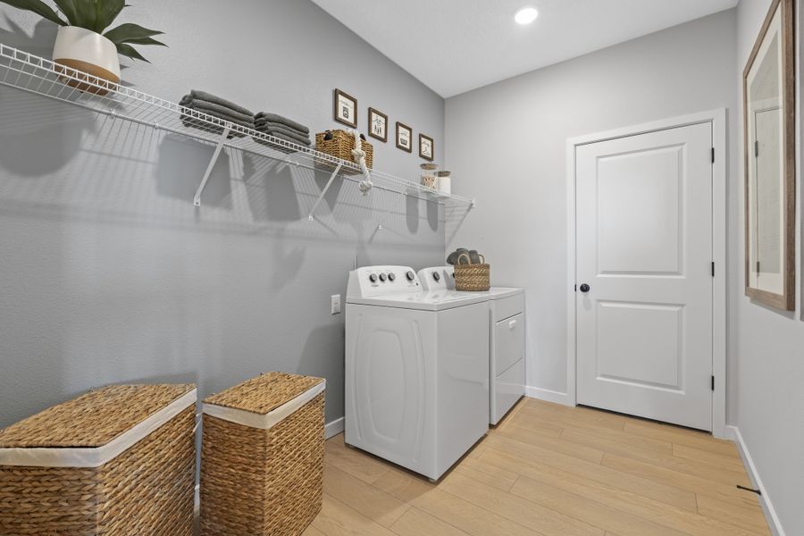 Kenai Model Home Laundry Room with Washer and Dryer and two Basket Hampers at Reserve East in Flagler Beach