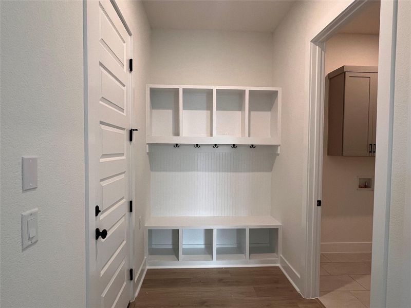 Mudroom with dark wood-type flooring and baseboards