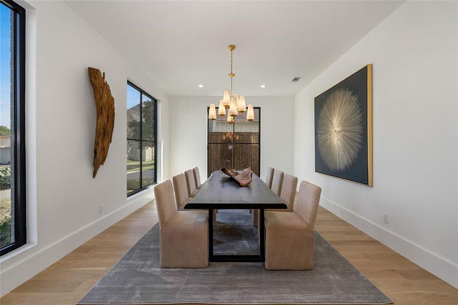 Dining area featuring wide plank wood-finish flooring and a contemporary gold-tone chandelier