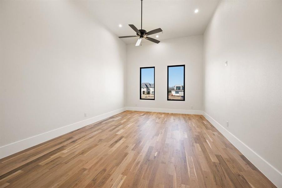 Exercise room with ceiling fan and built to hold extra weight from work out machines/weights.