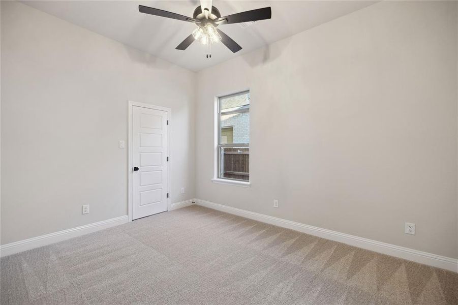 Empty room with light carpet and ceiling fan