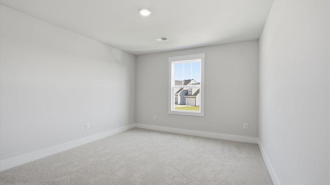 Notable secondary bedroom offering cozy carpeted flooring and a stylish walk-in closet
