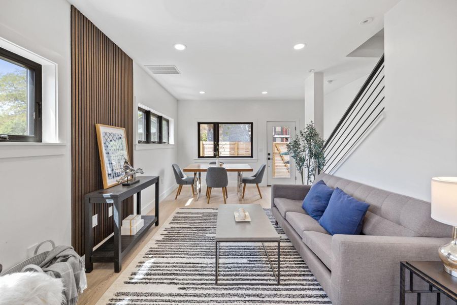 Living room featuring recessed lighting, light wood-style floors, and stairway