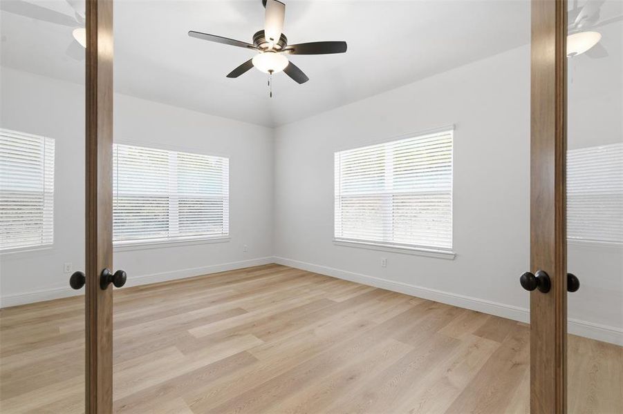 Spare room with french doors, light wood finished floors, and ceiling fan Spare room with french doors, light wood finished floors, and ceiling fan