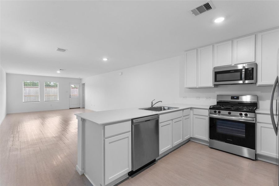Kitchen offers generous countertop space with an open view into the living room.