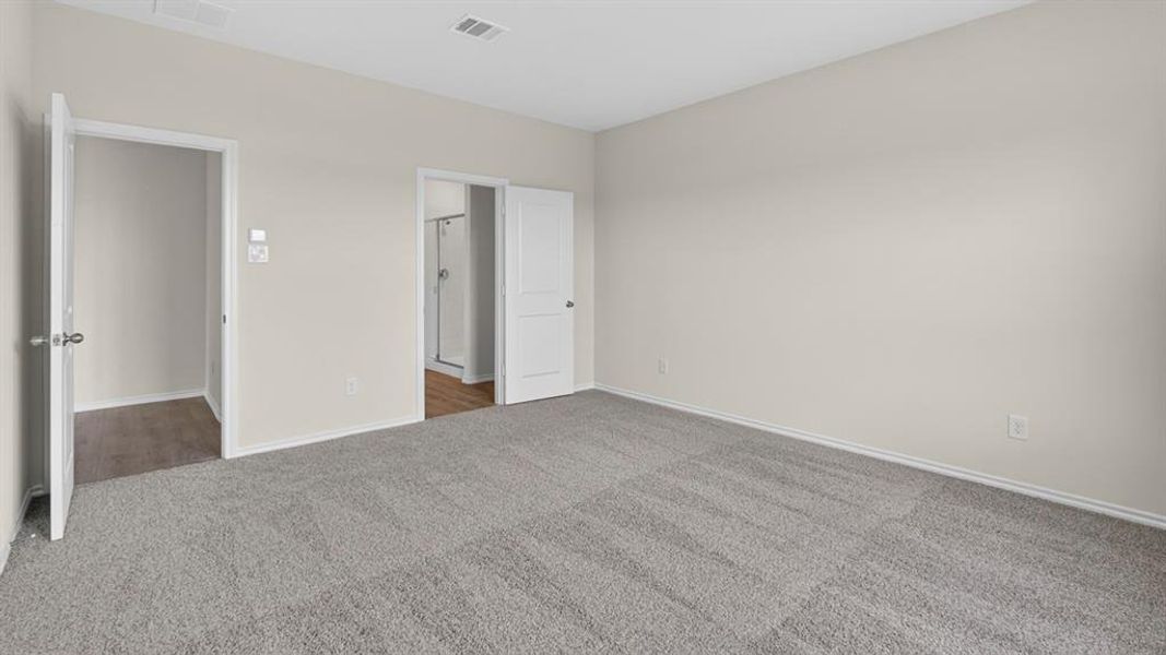 Carpeted room with light neutral wall paint, two interior doorways, and white baseboards