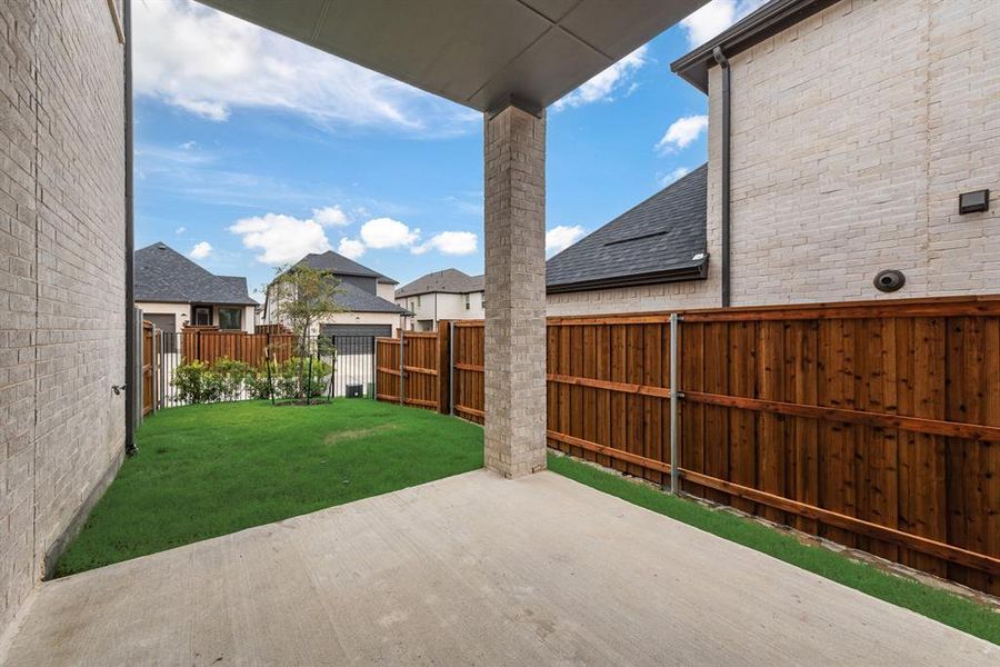 Fenced backyard with a patio area Fenced backyard with a patio area