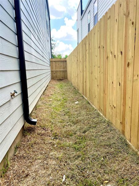 Side yard with a new wooden fence, perfect for added privacy. Side yard with a new wooden fence, perfect for added privacy.