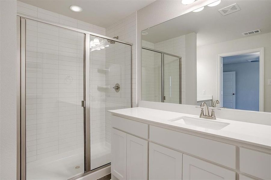 Full bath with a shower stall and visible vents