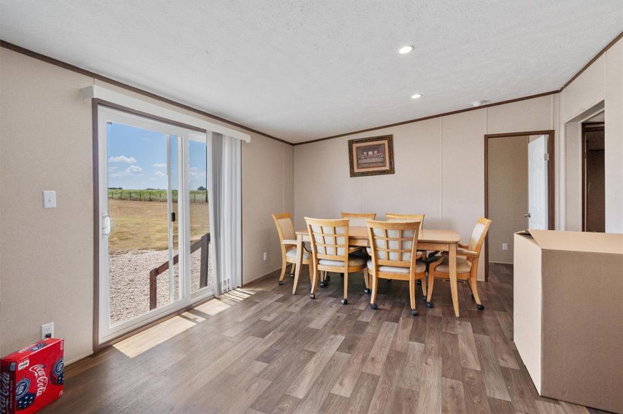 A sliding glass door opens to the outdoors from this inviting dining space featuring wood-look flooring.