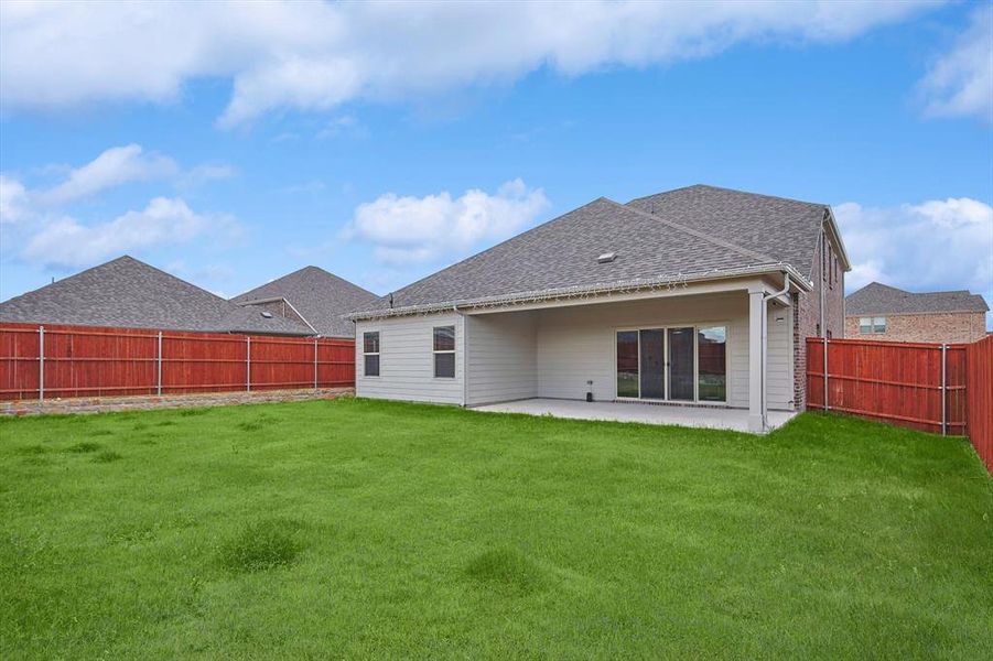 Rear view of house with a patio area and a yard