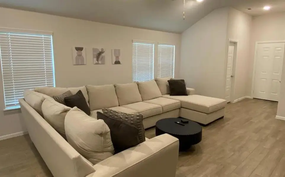 Living area featuring lofted ceiling and wood finished floors Living area featuring lofted ceiling and wood finished floors