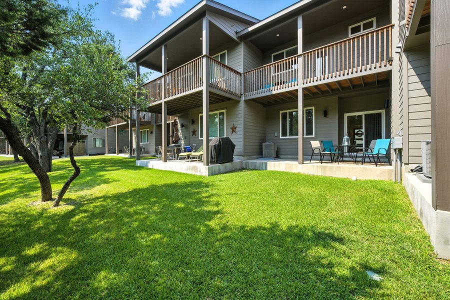 Back of property featuring a patio area and a lawn Back of property featuring a patio area and a lawn