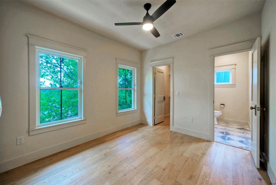 Bedroom #3 has well-lit interior space featuring warm hardwood floors and ample natural light from two large windows.