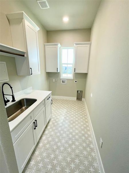 Laundry area with light floors, cabinet storage and utility sink with hanging space over sink