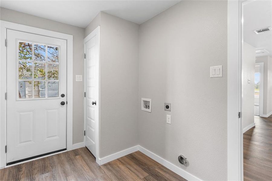 Laundry area with dark wood-type flooring, washer hookup, and hookup for an electric dryer