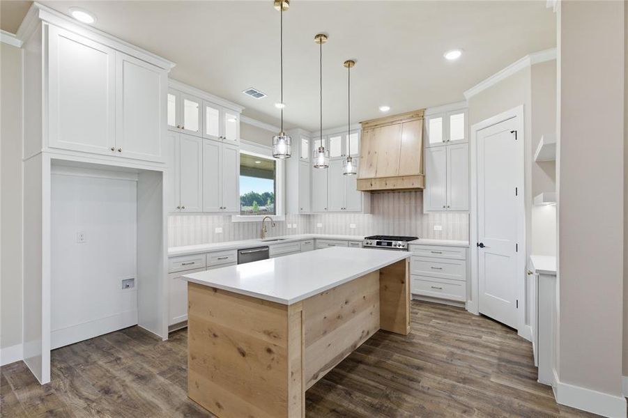 Kitchen featuring a wood-finish island with a white countertop, white shaker-style cabinetry, and wood-finish flooring