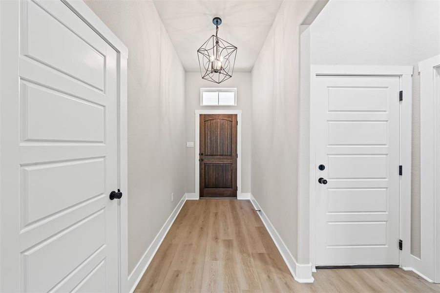 Entryway with a chandelier and wood finished floors Entryway with a chandelier and wood finished floors