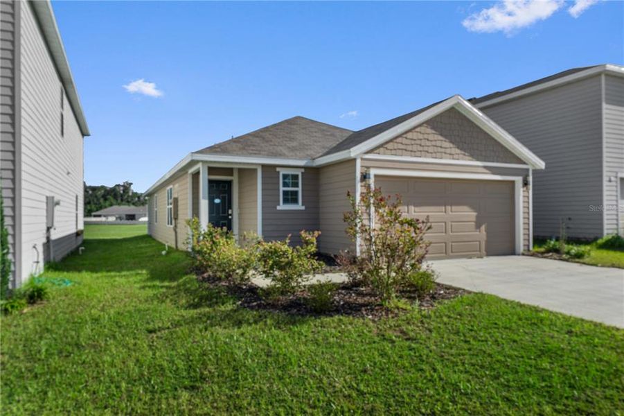Front exterior of a new home in Avalon Woods, Newberry, FL, highlighting curb appeal (Image 24).