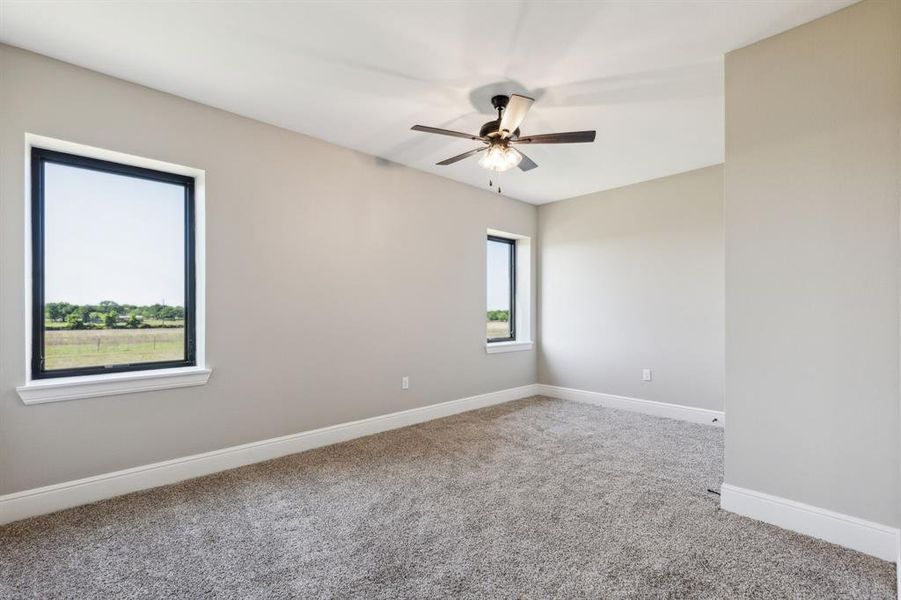 Spare room with carpet flooring, a ceiling fan, and baseboards Spare room with carpet flooring, a ceiling fan, and baseboards