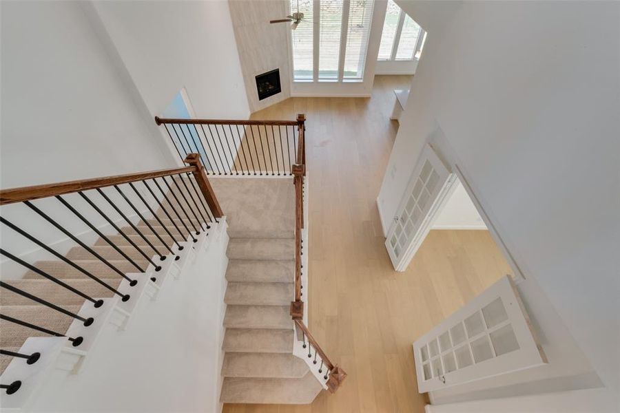 Staircase featuring a towering ceiling and hardwood / wood-style floors