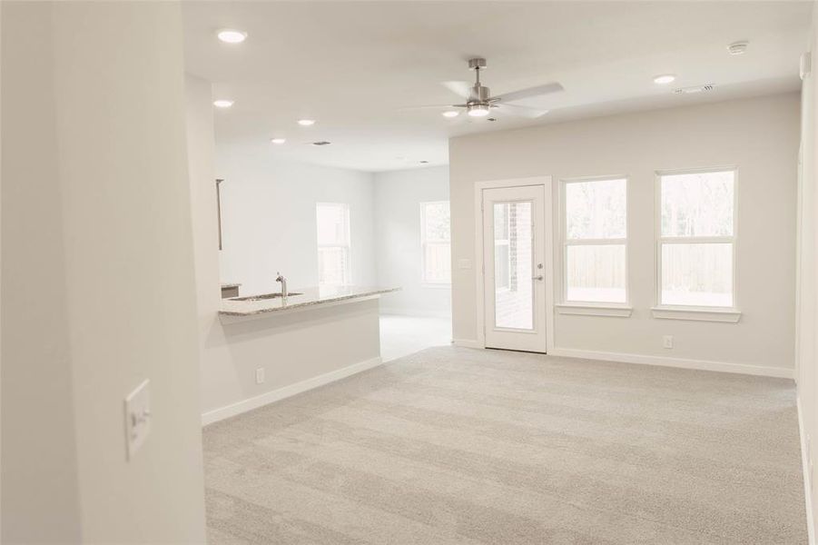 Carpeted spare room with ceiling fan