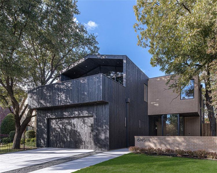 View of side of home featuring concrete driveway, a garage, and brick siding
