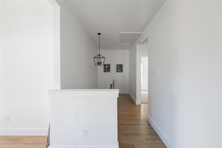 Hallway with attic access and light wood-type flooring Hallway with attic access and light wood-type flooring