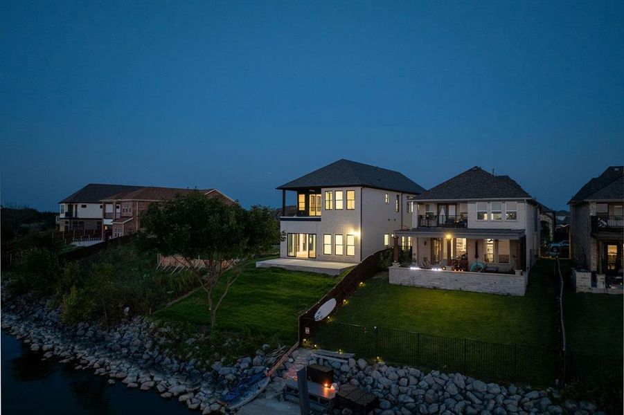 Back of house with a patio, a balcony, an outdoor fire pit, a water view, and a fenced backyard