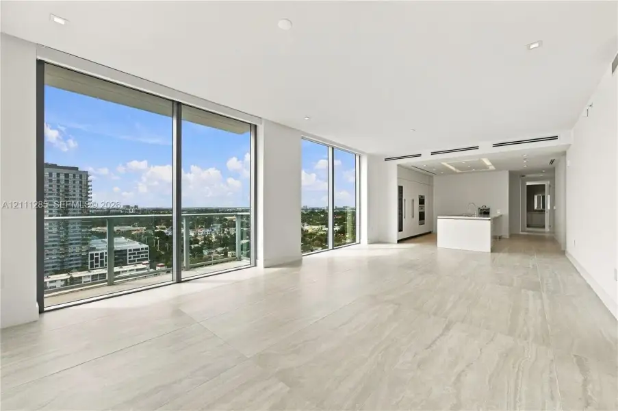 Floor-to-ceiling glass windows, expansive stone-finish flooring, recessed lighting, integrated kitchen appliances, and a minimalist stone-top island Floor-to-ceiling glass windows, expansive stone-finish flooring, recessed lighting, integrated kitchen appliances, and a minimalist stone-top island