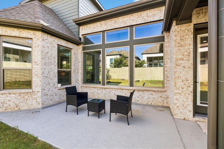 Expansive outdoor patio featuring light-toned brickwork and large windows with dark trim Expansive outdoor patio featuring light-toned brickwork and large windows with dark trim