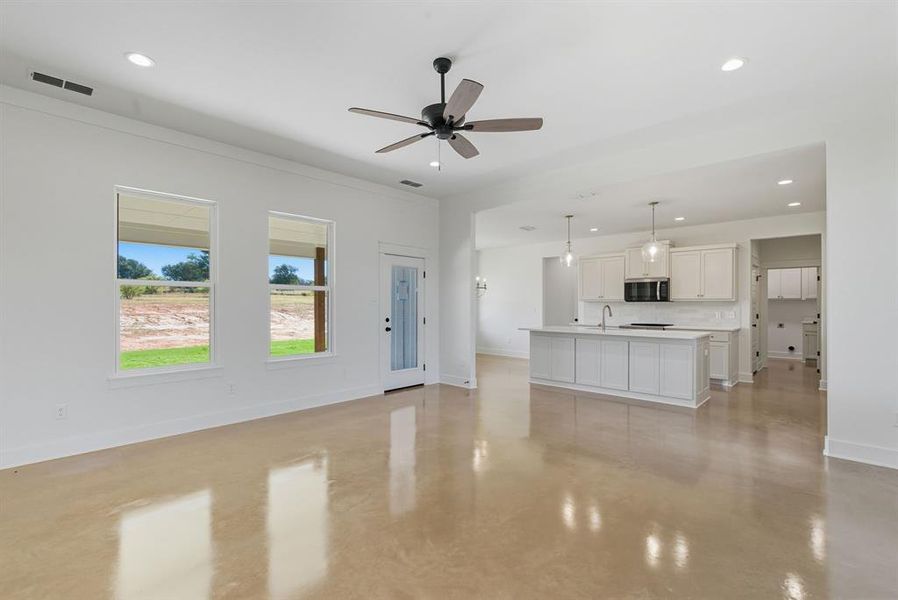 Unfurnished living room featuring finished concrete floors, recessed lighting, and ceiling fan