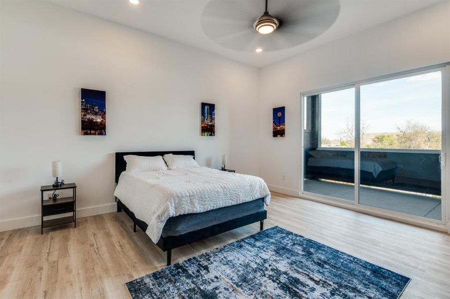 Spacious primary suite offering panoramic Downtown Dallas views fireplace and direct access to a private covered patio with a ceiling fan—perfect for relaxing in comfort. Spacious primary suite offering panoramic Downtown Dallas views fireplace and direct access to a private covered patio with a ceiling fan—perfect for relaxing in comfort.