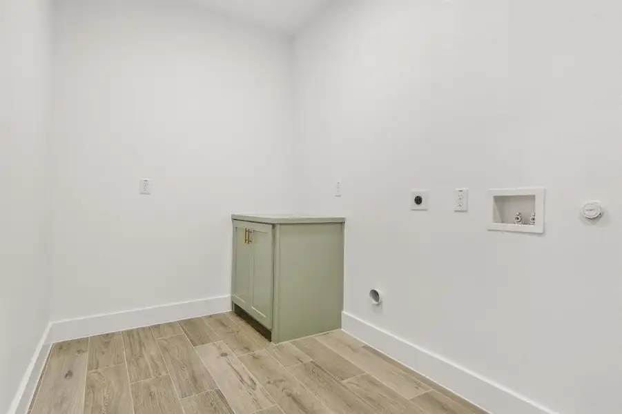 Laundry room featuring wood finish floors, electric dryer hookup, hookup for a washing machine, and cabinet space Laundry room featuring wood finish floors, electric dryer hookup, hookup for a washing machine, and cabinet space